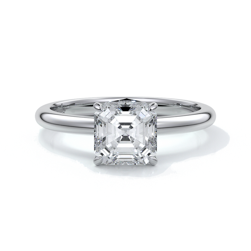 Platinum ring with emerald diamond secured with four claws