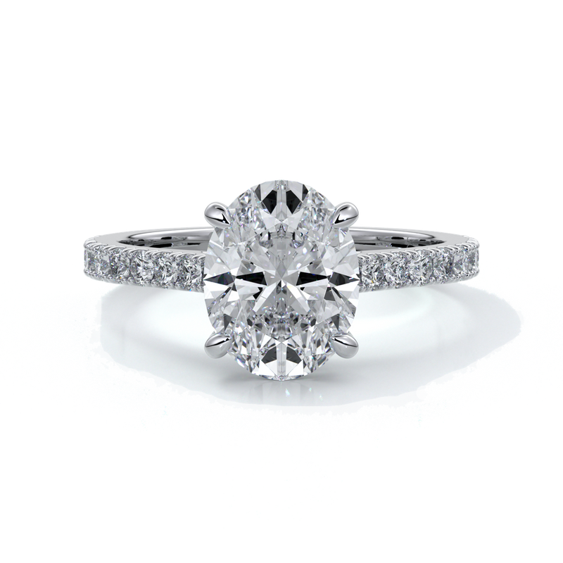 White gold ring with oval diamond secured with four claws with diamond on the shoulders