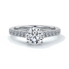 Platinum ring with round diamond secured with four claws with diamonds on the shoulders