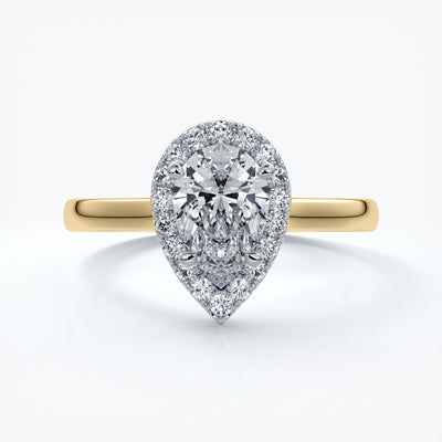 Gold ring with a one carat pear cut diamond in a cathedral halo setting with a slim comfort fit style band