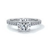 Platinum ring with round diamond secured with four claws in a cathedral setting with shoulder diamonds