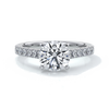 Platinum ring with round diamond secured with four claws in a cathedral setting with shoulder diamonds