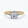 Gold diamond ring with four claws attaching diamond with two smaller diamonds on eachs side
