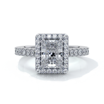 Platinum ring with a one point two carat, a radiant cut emerald diamond in a cathedral setting with a handset scalloped diamond band and halo