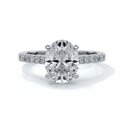 White gold ring with oval diamond secured with four claws with diamond on the shoulders