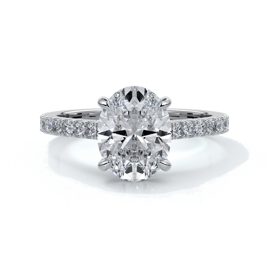 White gold ring with oval diamond secured with four claws with diamond on the shoulders