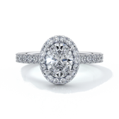 Platinum ring with one carat oval cut diamond in a cathedral style setting with scallop set shoulder diamonds and halo