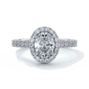 Platinum ring with one carat oval cut diamond in a cathedral style setting with scallop set shoulder diamonds and halo