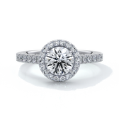 Platinum ring with a one and a half carat round diamond secured in four claws with a halo setting around the center diamond