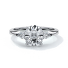 Platinum ring with a cushion cut center diamond and pear diamonds enhancing the trilogy